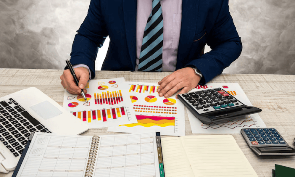 financial-inspector-making-report-financial-planning-report-using-graph-chart-paper-laptop-income-budget-sale-this-year_359031-11240 التسجيل في ضريبة الشركات والقيمة المضافة